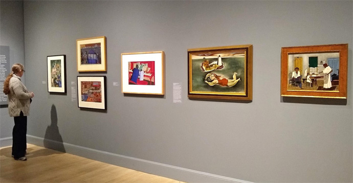 「イーデス・ハルパートとアメリカ美術の台頭」展の展示風景。中央から右へ順番にジェーコブ・ローレンス《音楽のお稽古》1943年、国吉康雄《泳ぐ人》1924年頃、ホレス・ピピン《日曜の朝食》1943年。筆写撮影