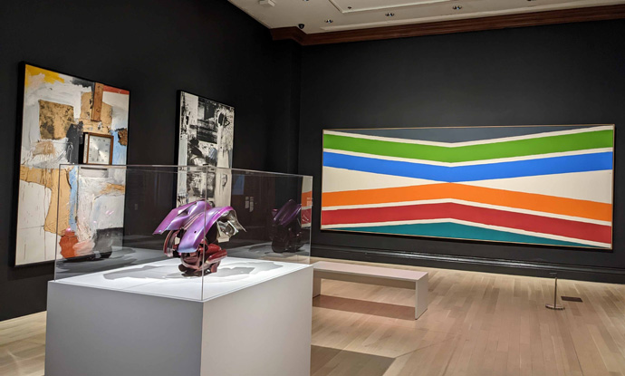 ジューイッシュ・ミュージアム「ニューヨーク：1962-1964年」展の展示風景。手前：ジョン・チェンバレンの立体、壁左から：ロバート・ラウシェンバーグ（2点）とケネス・ノーランドの絵画　筆者撮影