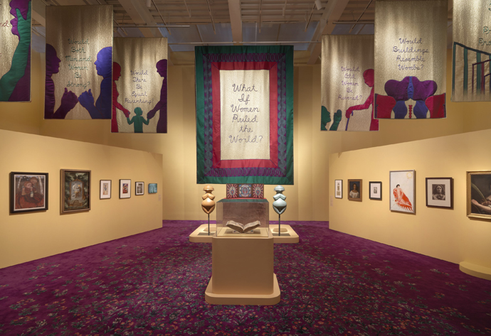 ニュー・ミュージアム開催「ジュディ・シカゴ―Herstory（彼女の歴史）」展の展示風景。代表作の《ディナー・パーティ》の代わりに、シカゴが2020年に制作した《女性の神性》の垂れ幕をつかい古今の女性作家たちの作品を紹介するグループ展示。タイトルの『女性の都市』は中世の作家、クリスティーヌ・ド・ピザンにちなむ。 Courtesy New Museum. Photo: Dario Lasagni