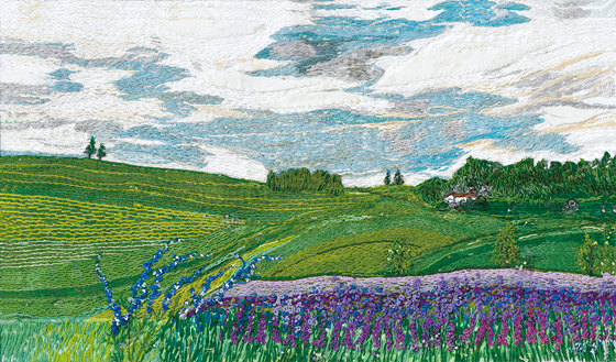 ラベンダー畑から広がる憧れの田園風景。繊細なステッチの描線が幾重にも重なり、鮮やかな色や光の流れとなって、画面全体にそよ風を吹かせています。特に人気の高い本作品は、今年出版の画集『岡田美佳 刺繍画の世界 ステッチ日和』（発行：㈱冨山房インターナショナル 123作品掲載）の表紙を飾っています。