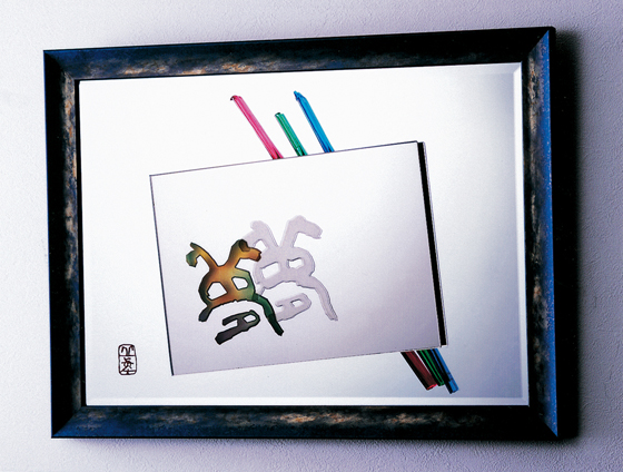 さまざまな木の彫書作品のなか、鏡に彫刻した夢と、更の夢。向かって右、自書の夢は自刻サンドブラストの凹刻。左の夢文字には、鏡の裏から彫り、鏡の中よりカラフルに。額に入れ、赤・緑・青のガラス棒に夢をつなぐ。表面は平の鏡そのもの、自身の姿も写る。道半ばの夢は鏡の遊び心に押され、さあ、夢の扉をあけて希望を叶えよう。